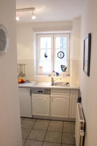 青斯特Achtern Diek 13a Whg 1的白色的厨房设有水槽和窗户