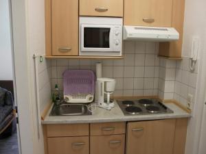 奥茨塞巴德·迪尔哈根-"Strandkrabbe" in der App-Anlage "Parkresidenz Dierhagen"-的一间带水槽和微波炉的小厨房