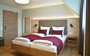 古坦泽尔赫贝尔Hotel Restaurant Klosterhof的一间卧室配有一张带红色枕头的大床