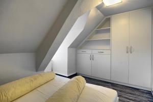 青斯特Altes Wasserwerk, FW 6的阁楼卧室配有白色橱柜和沙发