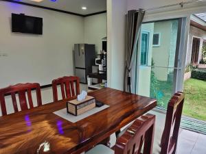 波普托Baan Nai Daeng Villa /Baannaidaengvilla的一间带木桌和椅子的用餐室