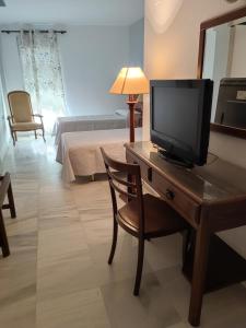 巴达霍斯塞万提斯酒店的客厅配有桌椅和电视机