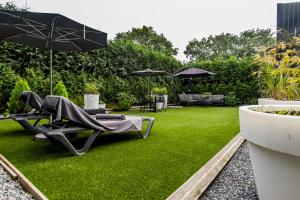 尼兰Luxexcellent super suite的花园设有椅子和遮阳伞及草地