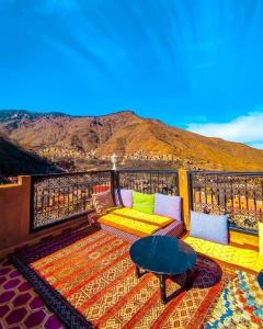 伊姆利尔里亚德阿特拉斯图卜卡勒酒店的阳台配有沙发和桌子,享有山景。