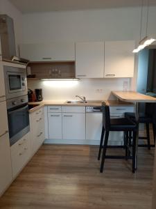格拉茨Ferienwohnung Christa的厨房配有白色橱柜和桌椅