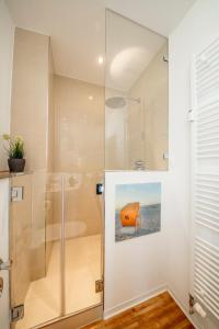 费曼城堡Strandburg Azurblau的浴室里设有玻璃门淋浴