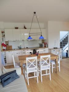 奥茨塞巴德·迪尔哈根Dorothee V6W5的厨房以及带木桌和椅子的用餐室。