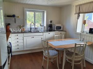 斯默根Nära Smögenbryggan的厨房配有桌椅和水槽。