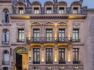波尔多Le Palais Gallien Hôtel & Spa的一座设有黄色门和阳台的建筑