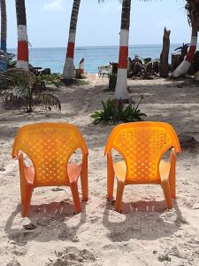 圣安德烈斯Sunny Beach Apartments的海滩上两把橙色椅子
