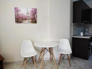 塞雷Anastasia's & Despoina's Apartment的厨房配有桌子和3把白色椅子