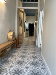 布鲁日B&B l'histoire de l'éclair的走廊设有瓷砖地板和长凳