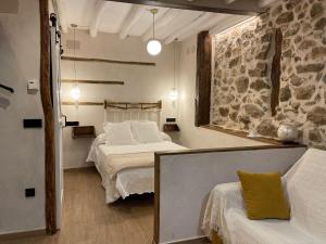 坎德拉里奥Apartamento La Herrerita的一间卧室设有两张床和石墙