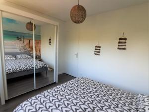 安德诺莱斯贝恩Résidence Estey T2 centre avec aperçu Bassin的一间卧室配有一张床和一面镜子的墙壁