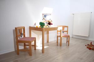 Meeschendorf"Ferienhof Sporleder" - Landhaus Nr1的一张桌子、两把椅子和一张桌子,上面有玩具