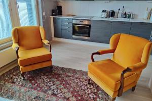 坦佩雷The Cutest Studio in Central Tampere的厨房里两把橙色椅子坐在地毯上