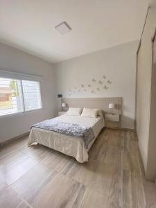 玛利亚镇La Pedrera Apart的白色的卧室设有床和窗户