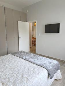 玛利亚镇La Pedrera Apart的一间卧室配有一张床和一台平面电视