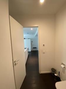 柏林Friedrichshain Apartment的走廊通往带浴室的客房