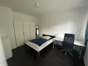 柏林Friedrichshain Apartment的一间卧室配有一张床、一张桌子和一把椅子