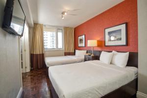 多伦多Town Inn Suites Hotel的酒店客房设有两张床和一台平面电视。