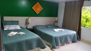 库里提巴Casa Klos - Quartos amplos的一间卧室设有两张床和绿色的墙壁