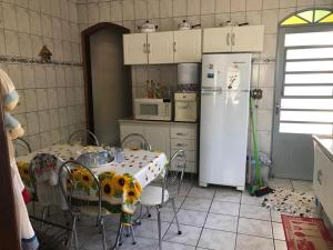 圣本图-杜萨普卡伊Casa do Descanso em São Bento do Sapucaí的厨房配有桌子和白色冰箱。