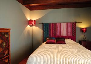 孔波尔塔Cocoon Eco Design Lodges的一间卧室配有一张带两个红色枕头的床