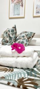 泰拉西尼Christian Guest House的床上有一堆毛巾和一朵花