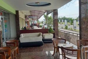 TjolomaduRedDoorz near Bandara Adi Soemarmo Solo的阳台配有沙发和桌椅。