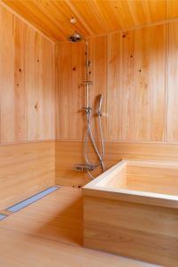 高山eph TAKAYAMA的木制墙壁上的一间带淋浴的浴室
