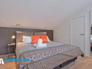 斯瑞德伯Cedar Creek 3的一间卧室配有一张带橙色枕头的大床