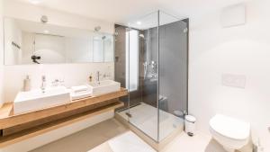 艾因西德伦圣乔治精品酒店的一间带两个水槽和玻璃淋浴间的浴室