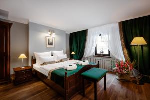 耶莱尼亚古拉巴伦酒店的一间卧室配有一张带绿色窗帘的大床
