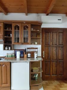 莱斯科瓦茨Nikolic Apartment的厨房配有木制橱柜和白色冰箱。
