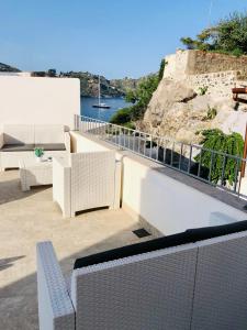 利帕里"Sweet Life" Casa Vacanze的阳台配有白色家具,享有水景。