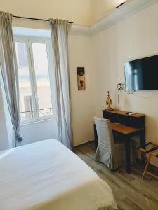 安齐奥Christy Suite Elegante appartamento nel centro storico di Anzio的配有一张床、一张书桌和一扇窗户的酒店客房