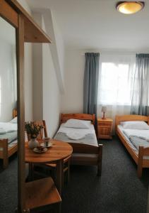 斯克拉斯卡波伦巴Villa Bożena的一间设有两张床、一张桌子和一张桌子的房间