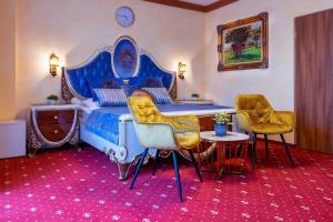 塔尔图汉莎酒店的一间卧室配有蓝色的床和两把椅子