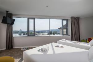布达佩斯B&B Hotel Budapest City的酒店客房设有两张床和大窗户。