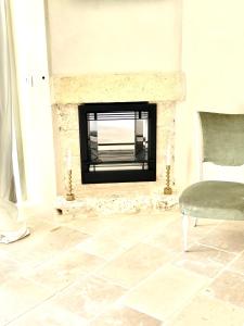 奥斯图尼Relais Grottone的客厅设有壁炉和椅子