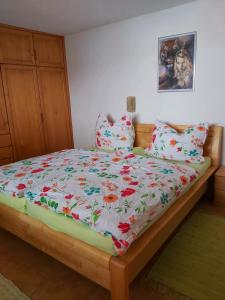 奥贝朴菲斯Appartment am Egghof的一张带花卉棉被和枕头的床