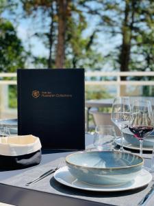 埃圭斯海姆Hotel SPA Husseren Collections - Proche Colmar - Eguisheim的一张桌子,上面放着一盘食物和酒杯