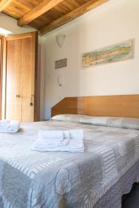 韦扎诺利古雷Ara dei Pre, Terre Marine的一间卧室配有一张床,上面有两条毛巾