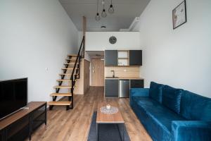 弗罗茨瓦夫RentPlanet - Apartamenty Zarembowicza II的一间带蓝色沙发的客厅和一间厨房