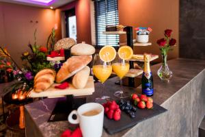 尼兰Luxexcellent super suite的桌子,上面放着面包和橙汁及水果杯