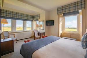 多诺赫皇家高尔夫酒店的卧室配有一张床、一张书桌和窗户。
