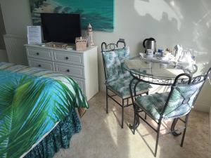 佩恩顿Vista Room with a Sea View的卧室配有一张床和一张桌子及椅子