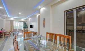 孟买Treebo Trend Welcome Apartments的一间设有玻璃桌和椅子的用餐室