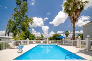 萨凡纳萨凡纳/普勒温德姆麦克罗特客栈&套房的一个带围栏和棕榈树的游泳池